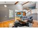 Open-concept living room with vaulted ceilings, hardwood floors, a staircase, and a glimpse of the kitchen at 9917 Grove Way # A, Westminster, CO 80031