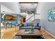 Open concept living room features a vaulted ceiling, hardwood floors, and a view of the staircase and kitchen at 9917 Grove Way # A, Westminster, CO 80031