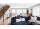 Bright open living room with hardwood floors, modern staircase, and dining area with a view of the street at 2048 Meade St, Denver, CO 80211