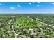 Aerial view of a suburban neighborhood, golf course, homes, and mature trees at 3245 S High St, Englewood, CO 80113