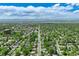 Wide aerial view of a city neighborhood with homes, mature trees, and distant mountain views at 3245 S High St, Englewood, CO 80113