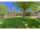 Spacious backyard with a lush lawn, mature trees, wood fence and brick trimmed garage at 3245 S High St, Englewood, CO 80113