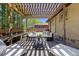 A charming backyard deck featuring a wooden pergola and outdoor seating arrangement at 3245 S High St, Englewood, CO 80113