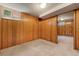 Basement room showcasing wood paneled walls, carpeted floor, and natural light from a window at 3245 S High St, Englewood, CO 80113