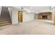 Finished basement showcasing a cozy stone fireplace, carpeted floors and direct access to stairs at 3245 S High St, Englewood, CO 80113