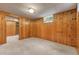 Basement room with paneled walls, carpeted floor, and window for natural light at 3245 S High St, Englewood, CO 80113