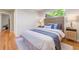 Comfortable bedroom with a cushioned headboard, hardwood floors, and sunlit windows at 3245 S High St, Englewood, CO 80113
