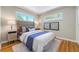 Sunlit bedroom featuring hardwood floors and light-colored walls with a cushioned headboard at 3245 S High St, Englewood, CO 80113