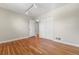 Hardwood bedroom with closet, white walls, modern lighting, and open doorway at 3245 S High St, Englewood, CO 80113