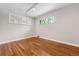 Well-lit bedroom with hardwood floors, large window, and modern lighting fixture at 3245 S High St, Englewood, CO 80113