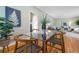 Open dining area with a glass-top table, wooden chairs, and views into the living room at 3245 S High St, Englewood, CO 80113