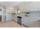 Bright kitchen with white cabinets, countertops, stainless steel dishwasher, and tile floor at 3245 S High St, Englewood, CO 80113