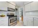 Well-lit kitchen with stainless steel oven, white cabinets, and tiled backsplash at 3245 S High St, Englewood, CO 80113