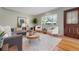 Bright living room features hardwood floors, modern furniture, and a large window at 3245 S High St, Englewood, CO 80113