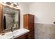 Stylish bathroom with a wood cabinet vanity, vessel sink, and a modern tiled shower, offering a spa-like retreat at 2190 S Uravan St, Aurora, CO 80013