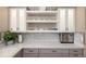 This kitchen features sleek gray cabinets, light countertops, floating shelves, and decorative mosaic tile backsplash at 2190 S Uravan St, Aurora, CO 80013
