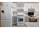 Kitchen features stainless steel appliances, gray cabinets, and ample counter space with workspace nearby at 2190 S Uravan St, Aurora, CO 80013