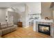 Open-concept living area with fireplace, hardwood floors, and a view into the modern kitchen and dining area at 2190 S Uravan St, Aurora, CO 80013