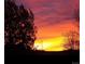 Stunning view of a colorful sunset sky over neighborhood rooftops with tree silhouettes and a power tower at 2190 S Uravan St, Aurora, CO 80013