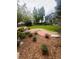 Landscaped backyard with trees, stone paths and established flower beds surrounding a green lawn at 12742 Clermont St, Thornton, CO 80241