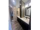 A modern bathroom featuring double sinks, with sleek black hardware and a decorative stone shower at 12742 Clermont St, Thornton, CO 80241