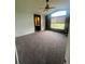 A neutral bedroom with a ceiling fan, window and a small walk through hallway at 12742 Clermont St, Thornton, CO 80241