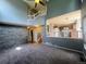 Bright living room featuring a stone accent wall, staircase to the second floor, and open access to the kitchen at 12742 Clermont St, Thornton, CO 80241