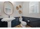 Stylish powder room with a pedestal sink and dark blue wainscoting at 624 Simmental Loop, Castle Rock, CO 80104