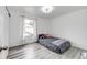 Cozy bedroom with wood-look flooring, a bright window, and a comfy bed with decorative pillows at 3679 S Zeno Way, Aurora, CO 80013