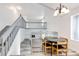 Open-concept dining area with modern lighting, seamlessly connected to a staircase, creating an airy atmosphere at 3679 S Zeno Way, Aurora, CO 80013