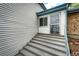Welcoming entryway with concrete stairs and secure screen door, leading into a bright and inviting home at 3679 S Zeno Way, Aurora, CO 80013