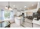 Bright kitchen with white cabinetry, marbled countertops, and stainless steel appliances, flowing into the dining area at 3679 S Zeno Way, Aurora, CO 80013