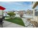 Landscaped backyard with artificial grass, stone pathway, and white fence at 8645 Coors St, Arvada, CO 80005