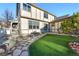 Landscaped backyard with a stone pathway, artificial turf, and outdoor seating for relaxation and entertainment at 8645 Coors St, Arvada, CO 80005