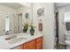 Well-lit bathroom with a spacious countertop, a modern faucet, and a shower with decorative curtain at 8645 Coors St, Arvada, CO 80005