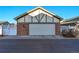 Attached two-car garage with brick accents and a well-maintained driveway for convenient parking at 8645 Coors St, Arvada, CO 80005