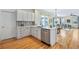 Bright kitchen featuring white cabinetry, hardwood flooring, and stainless steel dishwasher at 8645 Coors St, Arvada, CO 80005