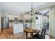 Well-lit kitchen with white cabinets, an island, stainless steel appliances, hardwood floors, and a dining area with slider door at 8645 Coors St, Arvada, CO 80005