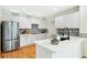 Bright kitchen features stainless steel appliances, wood floors, and modern black and white backsplash at 8645 Coors St, Arvada, CO 80005