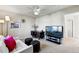 Cozy living room with ceiling fan, desk, modern TV and white sofa with ottoman seating, perfect for relaxing and entertaining at 8645 Coors St, Arvada, CO 80005