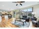 Open concept living room with hardwood floors, large windows, ceiling fan, and a view of the kitchen and dining area at 8645 Coors St, Arvada, CO 80005