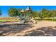 Community playground with slides, climbing structures, and a wood chip ground covering, surrounded by mature shade trees at 8645 Coors St, Arvada, CO 80005