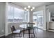 Bright dining area featuring a glass table set, chandelier lighting, and large windows leading to the patio at 1640 Mcmurdo Trl, Castle Rock, CO 80108