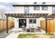 Backyard with a paved patio and modern seating area under a wooden pergola at 2134 S Galapago, Denver, CO 80223