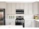 Stylish kitchen featuring modern stainless steel appliances, sleek grey cabinets, and white subway tile backsplash at 2134 S Galapago, Denver, CO 80223