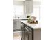 Bright kitchen features a large island with white countertop, grey cabinetry, and updated fixtures at 2134 S Galapago, Denver, CO 80223