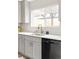 Well-lit kitchen showcasing stainless steel sink, modern faucet, and shaker-style cabinetry beneath a bright window at 2134 S Galapago, Denver, CO 80223