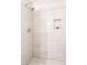 Spa-like shower with white subway tile, penny tile floor, and built-in niche for toiletries at 2134 S Galapago, Denver, CO 80223