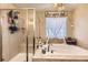 Bathroom showcasing a glass shower stall, luxurious soaking tub, and stylish decorative features for a spa-like experience at 26072 E Fremont Pl, Aurora, CO 80016