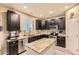 Well-appointed kitchen with dark cabinetry, granite countertops, stainless steel appliances, and island at 26072 E Fremont Pl, Aurora, CO 80016
